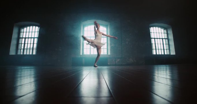 beautiful ballerina in white dress performs pirouettes in the Studio, slow motion
