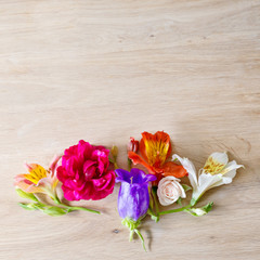 Creative arrangement made of different flowers on wooden background with space for text.