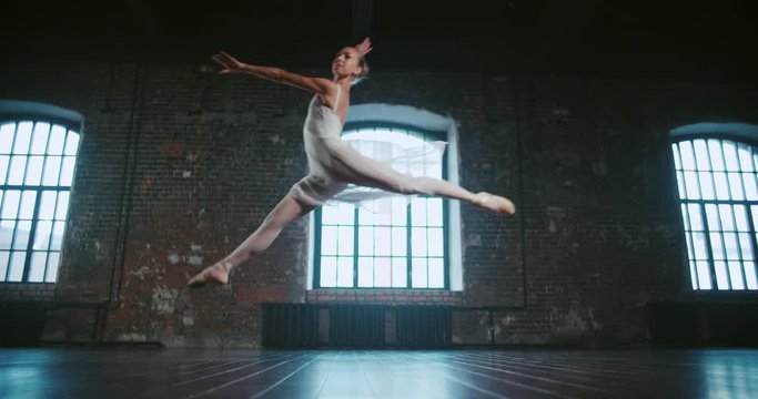 beautiful girl dancer performs a jump, and classical ballet in the loft design Studio,slow motion