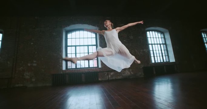 beautiful girl ballerina performs pirouettes of classical ballet to the loft design Studio,slow motion