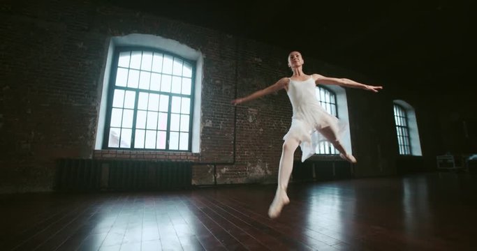 beautiful girl ballerina performs pirouettes of classical ballet to the loft design Studio,slow motion