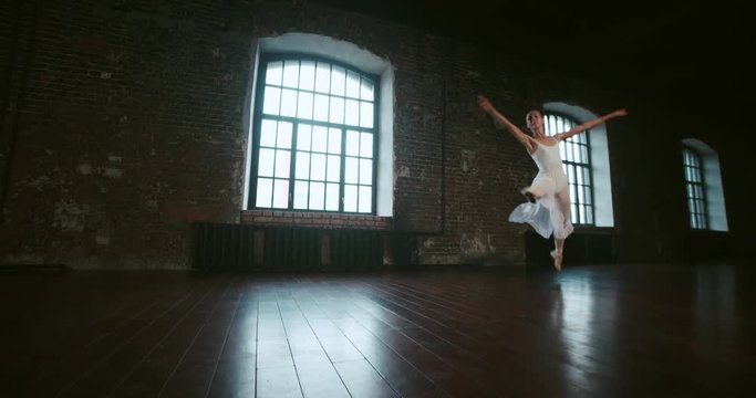 beautiful girl ballerina performs pirouettes of classical ballet to the loft design Studio,slow motion