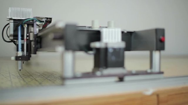 Crossbar of laser cut machine moves along canvas