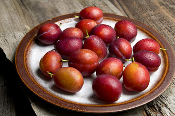 Świeże dojrzałe śliwki na drewnie