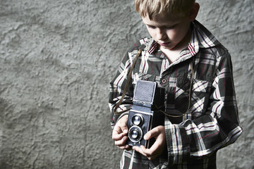 Child blond boy with vintage photo film camera photographing © Petr Bonek