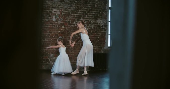 adult ballerina coached a little girl daughter to dance class