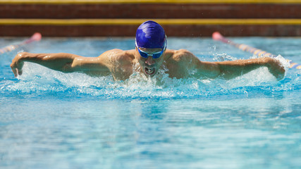 Mann schwimmt Schmetterling auf Schwimmbahn © TeamDF