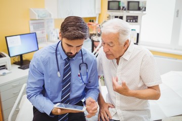 Doctor discussing with patient over digital tablet