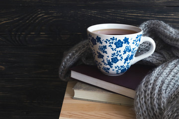 Warm knitted plaid, cup of tea and books