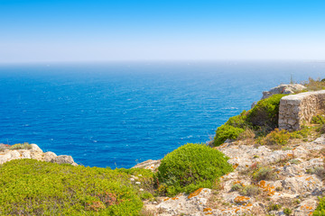 Menorca island cliff edge travel background with blue sky and water, Spain.