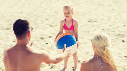 Fototapeta premium happy family playing with inflatable ball on beach