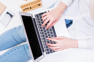 Fototapeta na wymiar Woman in jeans using laptop