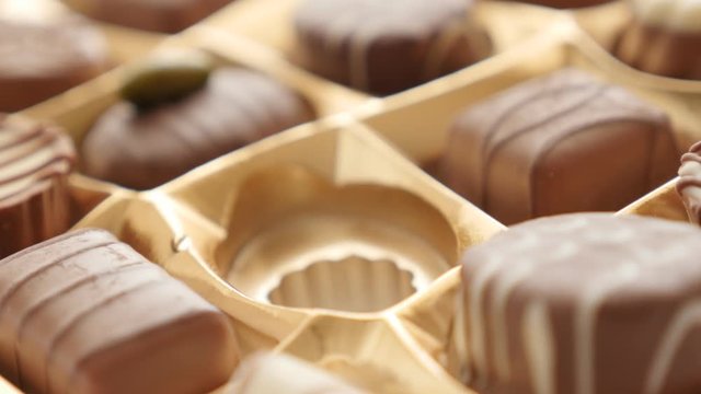 Package box picking one of lot chocolates 4K 2160p 30fps UltraHD footage - Hand pick gift assorted chocolate box tasty dessert background 4K 3840X2160 UHD video 