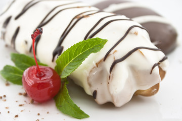 Eclair with chocolate icing and mint, on white background. Selec