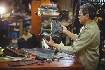 Shoemaker examining a leather boot