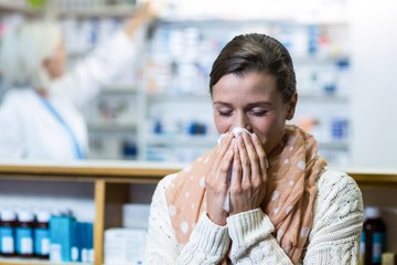 Customer covering her nose while sneezing - Powered by Adobe