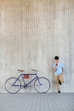 man with smartphone and fixed gear bike on street