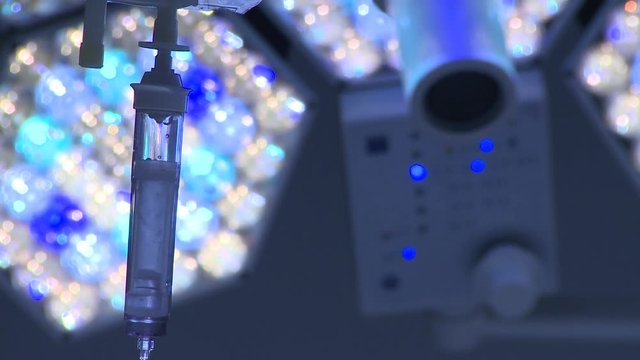 Intravenous drip pull focus to surgery light. Hand switches light on/off. 

(Filmed in ProRes with high dynamic range for flexibility for image grading)