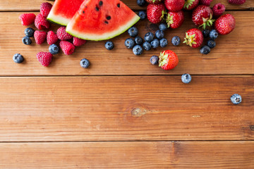 Naklejka premium close up of fruits and berries on wooden table
