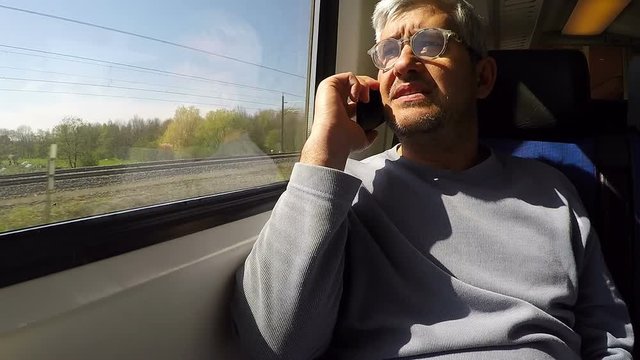Man Traveling By Train Using Cellphone