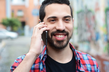 Young latin man talking on the phone.