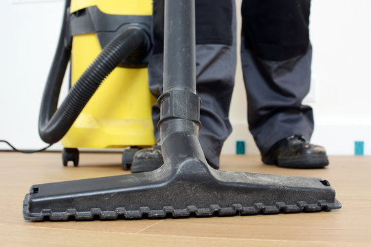 Handwerker mit Staubsauger beim Staubsaugen