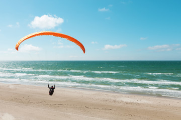 Paragliding on the deserted beach - obrazy, fototapety, plakaty