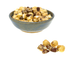 Gourmet popcorn with nuts in a bowl with a portion in the foreground.
