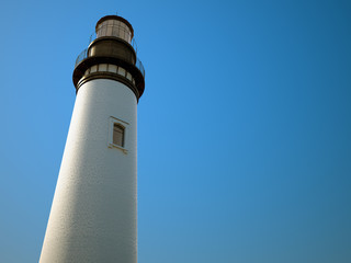 white lighthouse with a blue sky in a sunny day