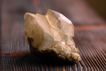 Rock crystal mineral stone on the wooden background. Quartz variety.
