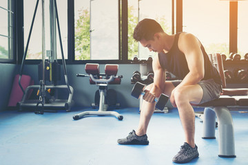 Man using dumbbell in public gymnasium