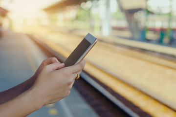 Woman using tablet on the railway station, hand holding tablet