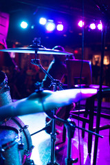 drums cymbals on stage with singer in background