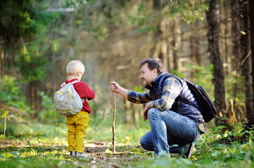 Father and his son walking during the hiking activities in forest