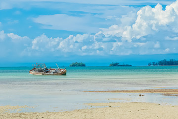 Old fisherman boat with anchor on the tropical beach