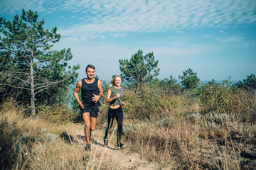 Obraz premium young sporty couple running in the wood 