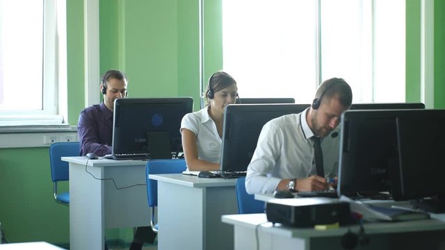 business colleagues with headsets using computers at the m dern office desk
