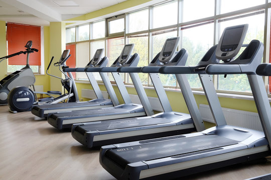 Interior of a modern fitness hall with treadmill