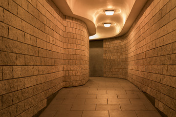 a curving pedestrian tunnel (subway) in the City of London, at night