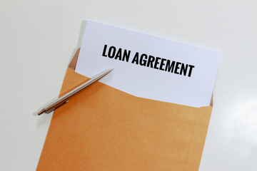 Loan agreement in envelope with pen on table - business concept