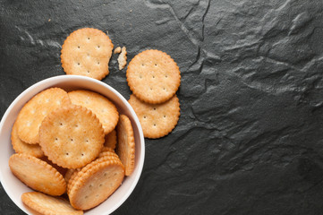 cracker stacked in white bowl over black granite
