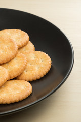 crackers cheese and crackers sugar in black plate on wood table