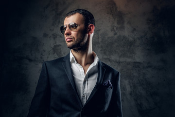 Portrait of male in sunglasses and grey business jacket.