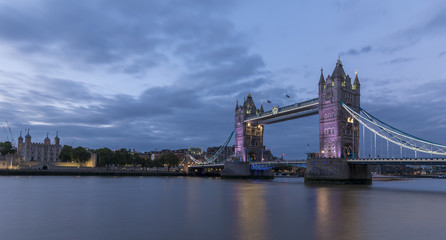 Obraz premium Tower Bridge, London, at sunset, with the river Thames in the foreground and the Tower of London across the river.