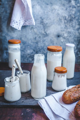 Natural yogurt and milk kefir on a rustic table. - obrazy, fototapety, plakaty