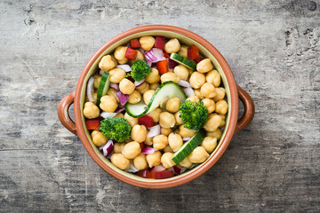 Chickpea salad in bowl on wooden background

