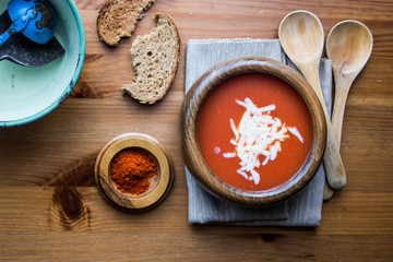 Tomato Soup with Cheese on a wooden surface..