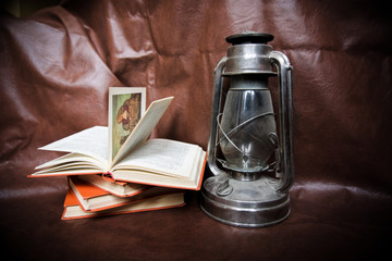 kerosene lamp and books on a brown background