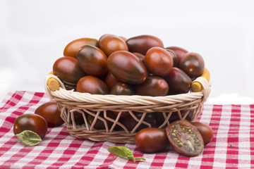 Obraz premium bunch of dark ripe juicy garden tomato in a basket