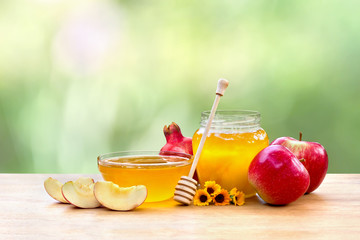 Honey, red apples, garnets and calendula flowers on wooden table on the blur natural background...